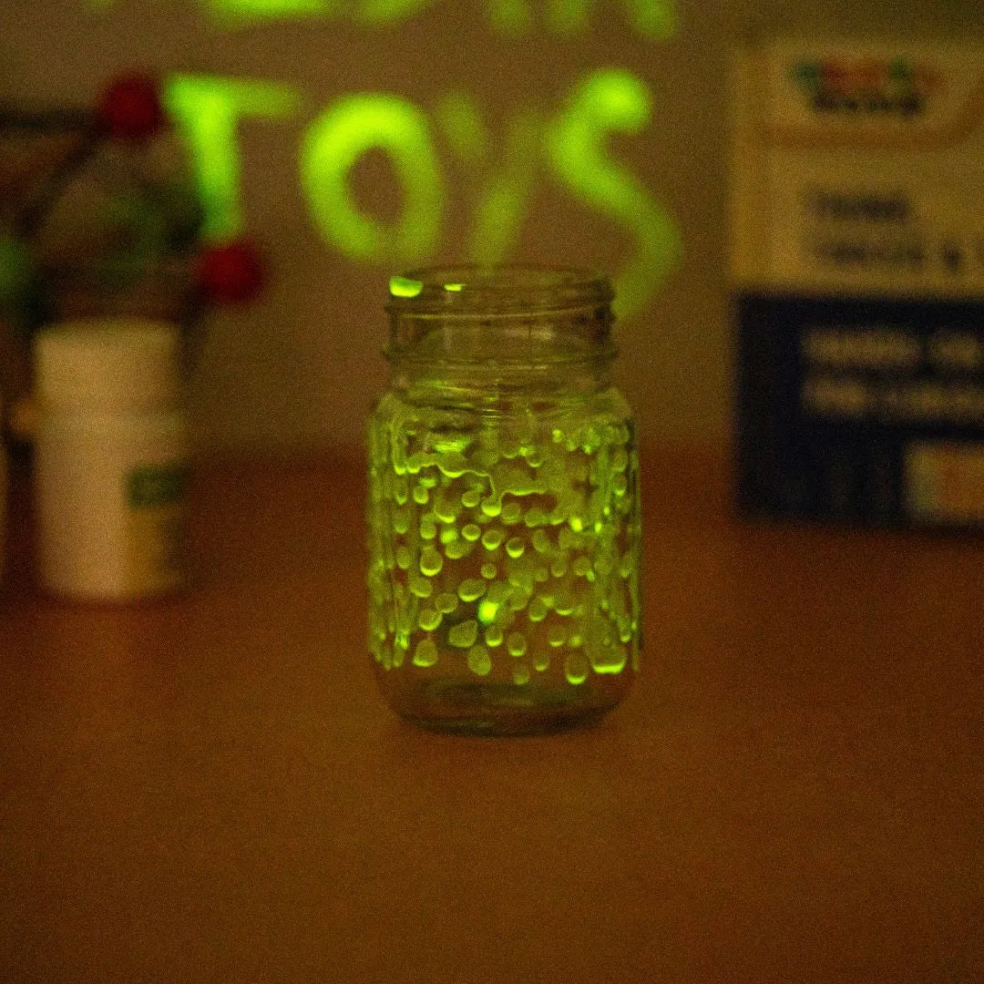 NESTA TOYS - Glow in dark toy, glow puzzle kids, glow activity kit, glow science toy, glow learning toy, glow educational toy, kids glow toy, glow toy set, fun learning toy, educational glow toy, kids activity toy Glass jar filled with glowing green beads shining in the dark during a glow in the dark science experiment for kids