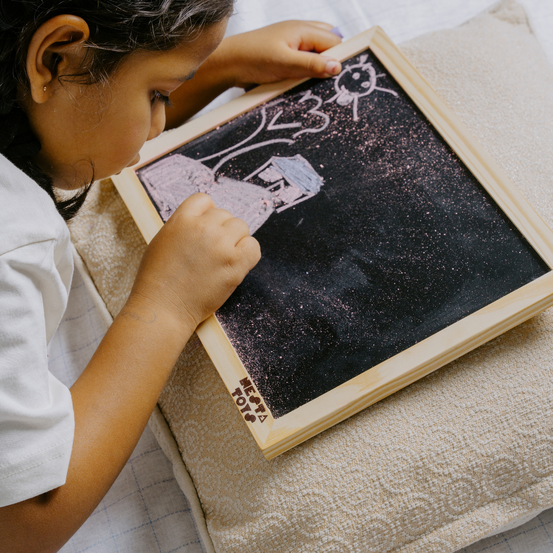 Kid drawing and writing on wooden chalkboard slate from NESTA TOYS.