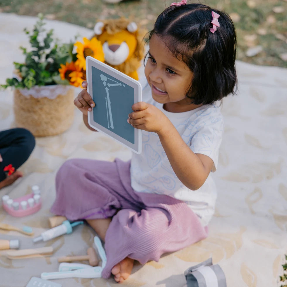 Kid playing with NESTA TOYS wooden doctor set, enjoying pretend medical role play and learning through imaginative play