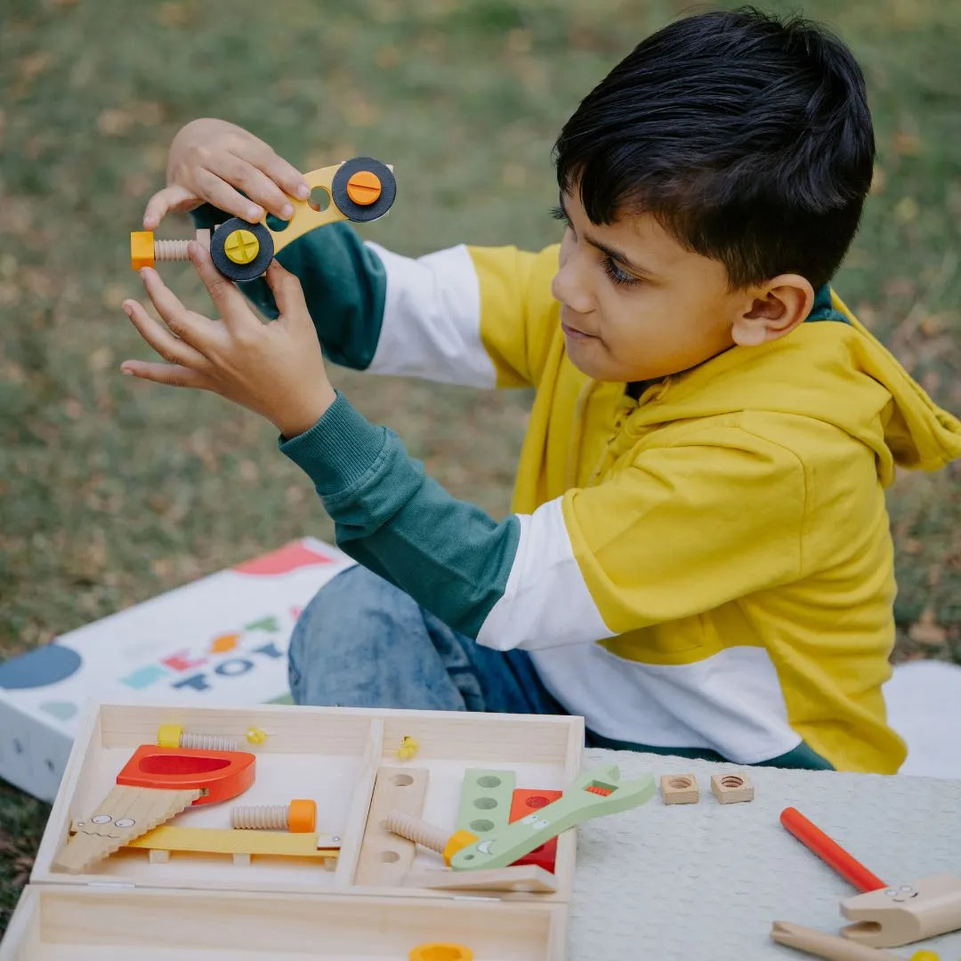 Kid playing with the Wooden Tool Kit Toy, using wooden tools and toolbox, developing creativity and motor skills