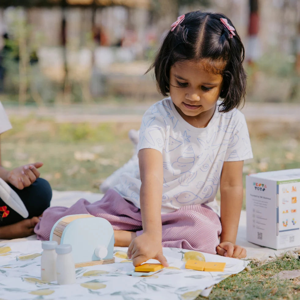 Kid playing with NESTA TOYS wooden bread pop-up toaster (blue) kitchen toy, enjoying safe pretend play and creative role-play activities.