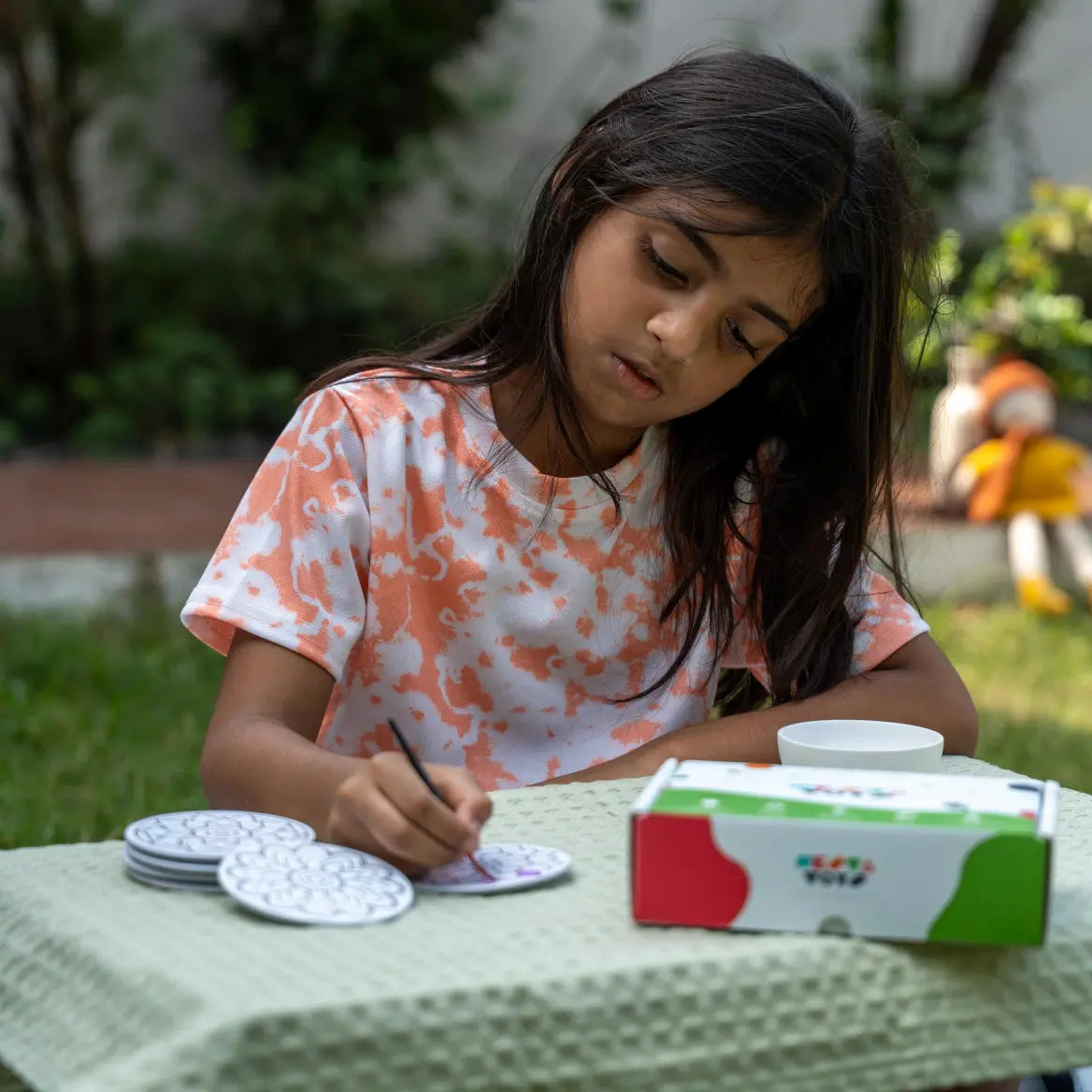 Child coloring a mandala art fridge magnet using bright colors
