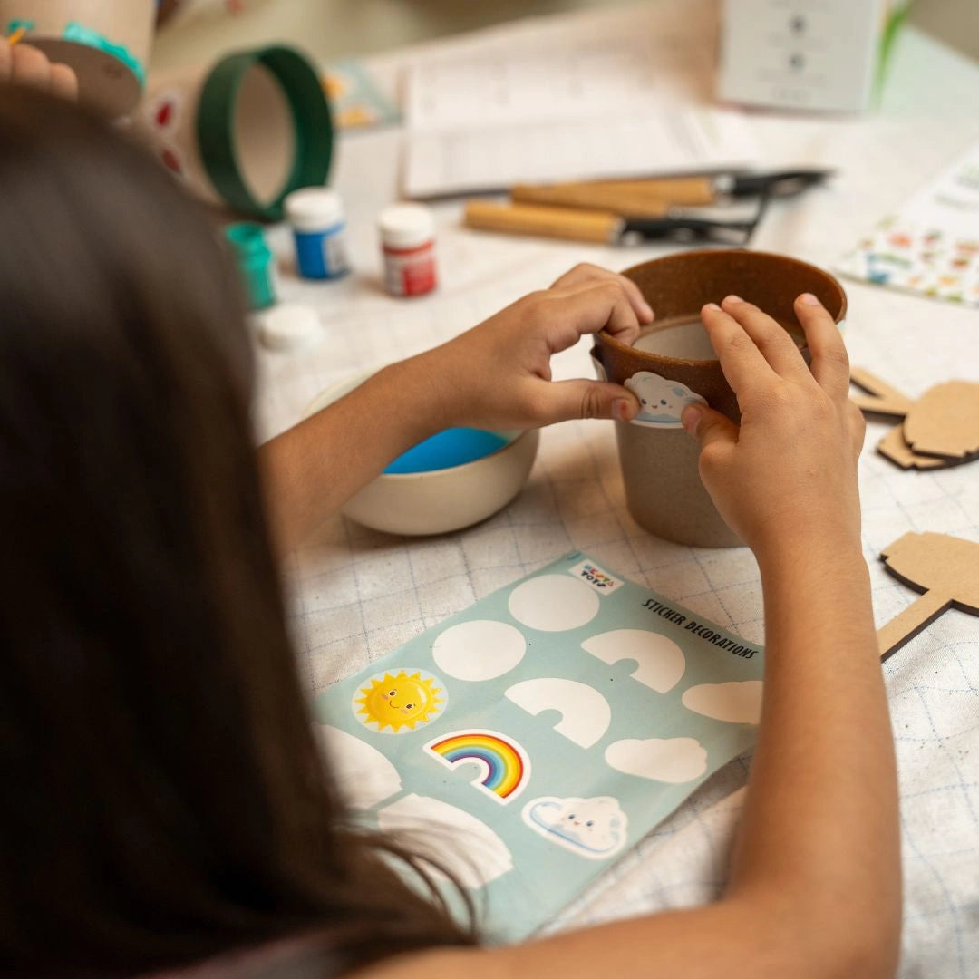 Child arranging pots and planting seeds with the DIY Gardening Kit